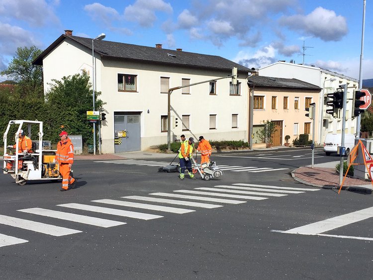 Foto: Straßenkreuzung in dörflicher Umgebung mit Arbeitern und Baugeräten